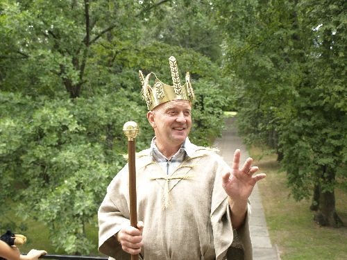Rukkikuningas Hans I Kruusamägi rukkimaarjapäeval Ülenurme mõisa häärberi rõdul pargi allee taustal