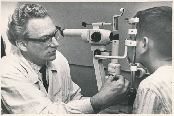 Portreefoto. Silmaarst Leo Schotter tegelemas patsiendiga. Tartu, 1970-1974. Foto Kaljo Raud.