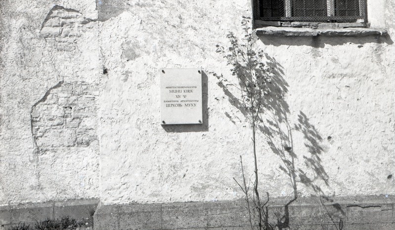 Arhitektuurimälestise tahvel Muhu kiriku seinal