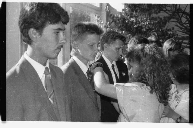 Kooli lõpuaktus; lõpetajale koolimärgi rindakinnitamine