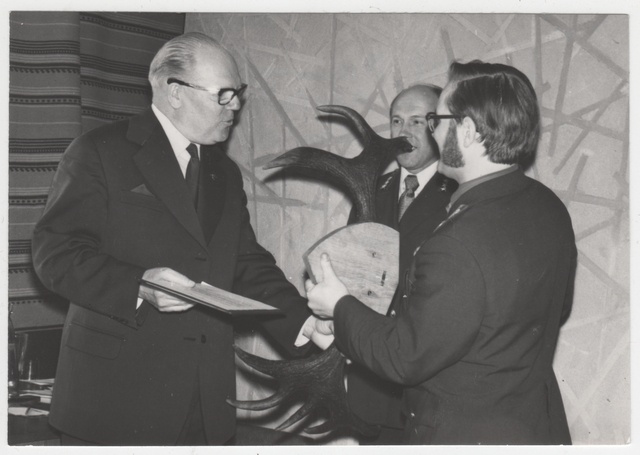 Metsakaitse ülem Henn Alton Jaan Vaarmannile pensionile mineku puhul kingitust üle andmas