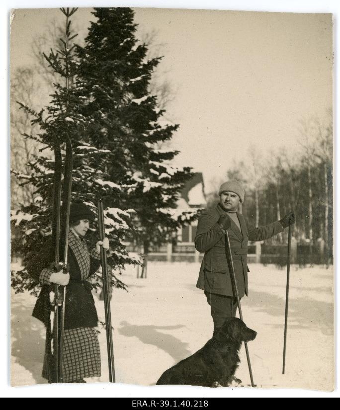 Johannes Vares suusatamas, tema taga Emilie Vares suusad käes, kõrval koer.