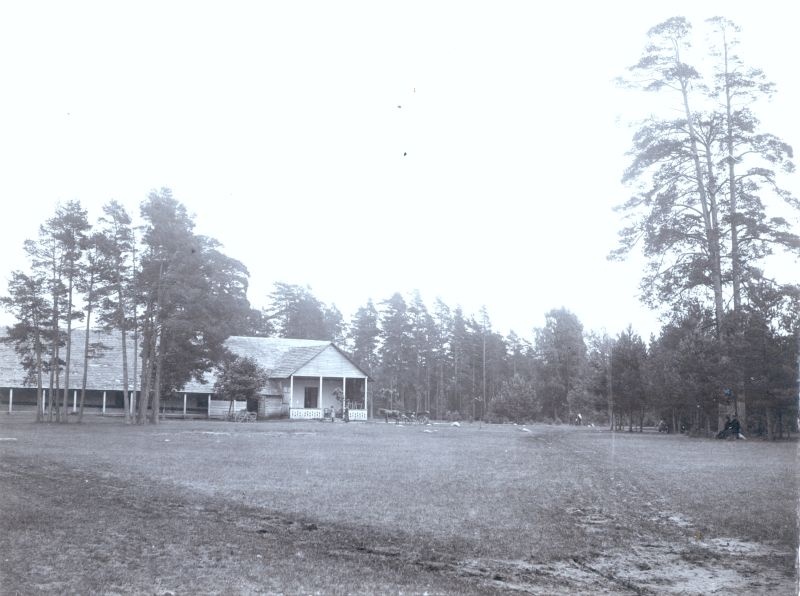 Foto. Vaade Ungru-Paralepa kõrtsihoonele männimetsas. Näha osa hoonest, õues laud toolidega, ukse ees hobusõiduk. u 1900. Foto Th. Haack.