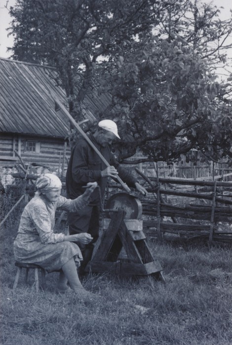 Foto Malvaste Mihkli talu peremees ja perenaine vikatit teritamas