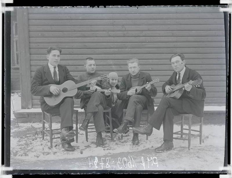 klaasnegatiiv, ülikondades mehed pillidega, nende taga Helmi Tohvelmann, 1920-30-ndad a.