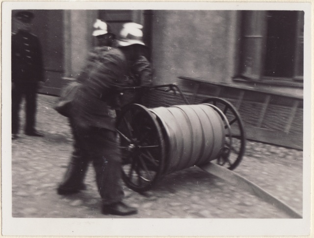 Kaks tuletõrjujat käruvärtent vedamas.