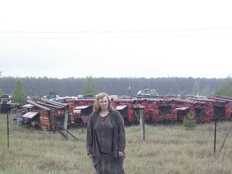 Taas Tšornobilis, mahajäänud masinapargi taustal Tšornobili veterani abikaasa