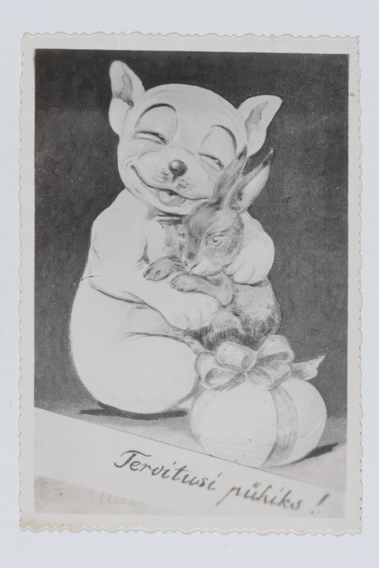 Fotopostkaart jänest kallistava koeraga ning tekstiga "Tervitusi pühiks!"