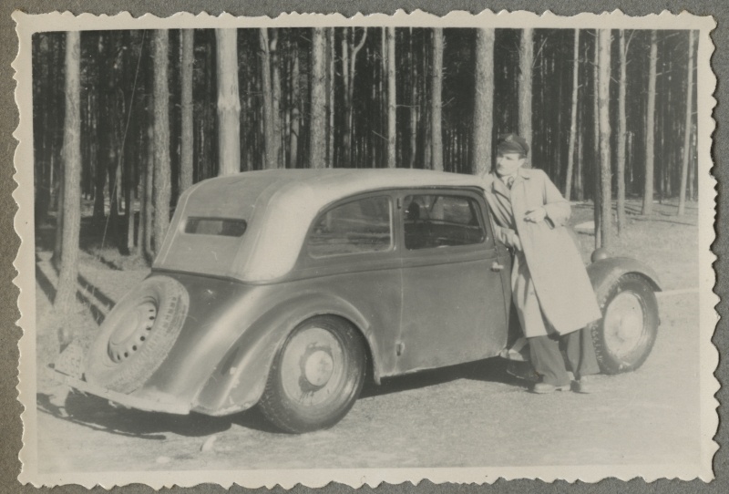 A man with a coat and coat in the background of a passenger car.