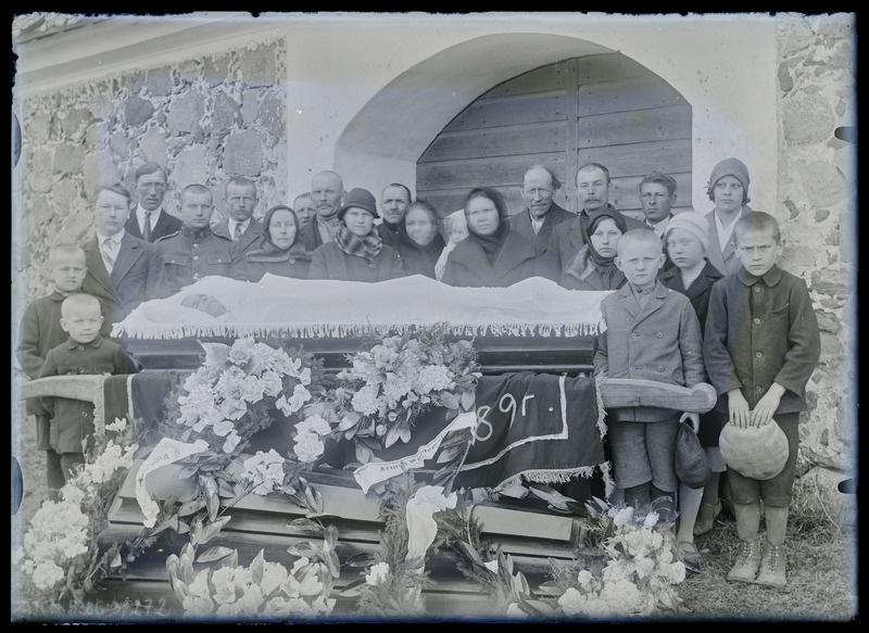 Grupiportree: matused, tundmatud leinajad sarga ümber. Musta rätiga keskel Leena Rannaste.