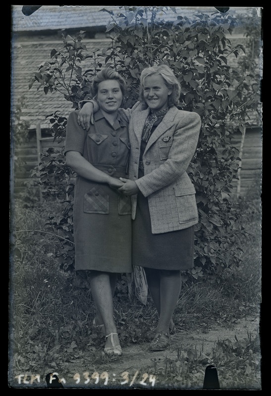 Kaks tundmatut naist põõsa taustal