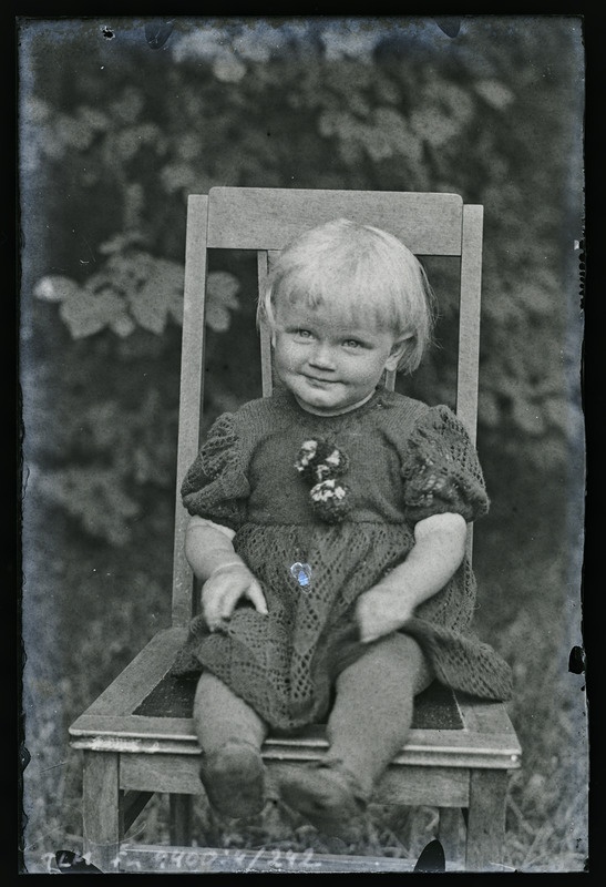 Portree: tundmatu väikelaps toolil istumas