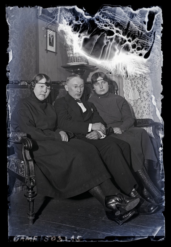 Hermann Jaakson koos kahe noore naisega. Diivanil istumas