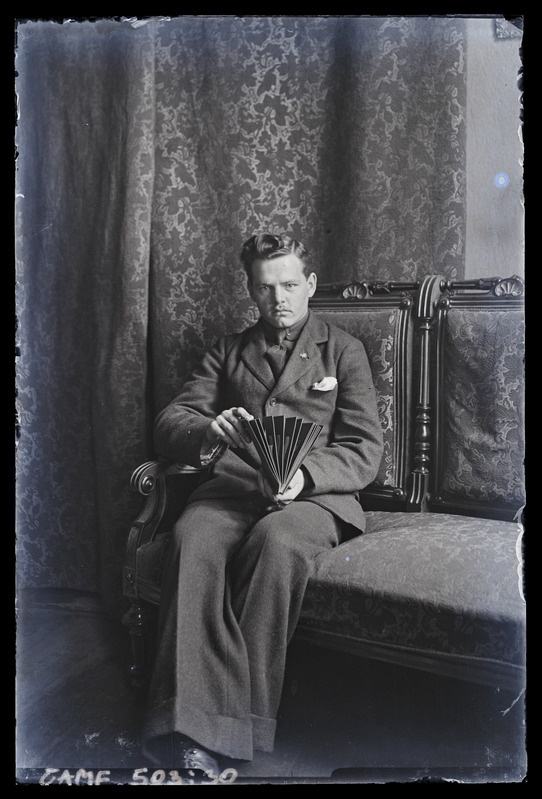 Mehe portree. Diivanil istumas, raamatuga