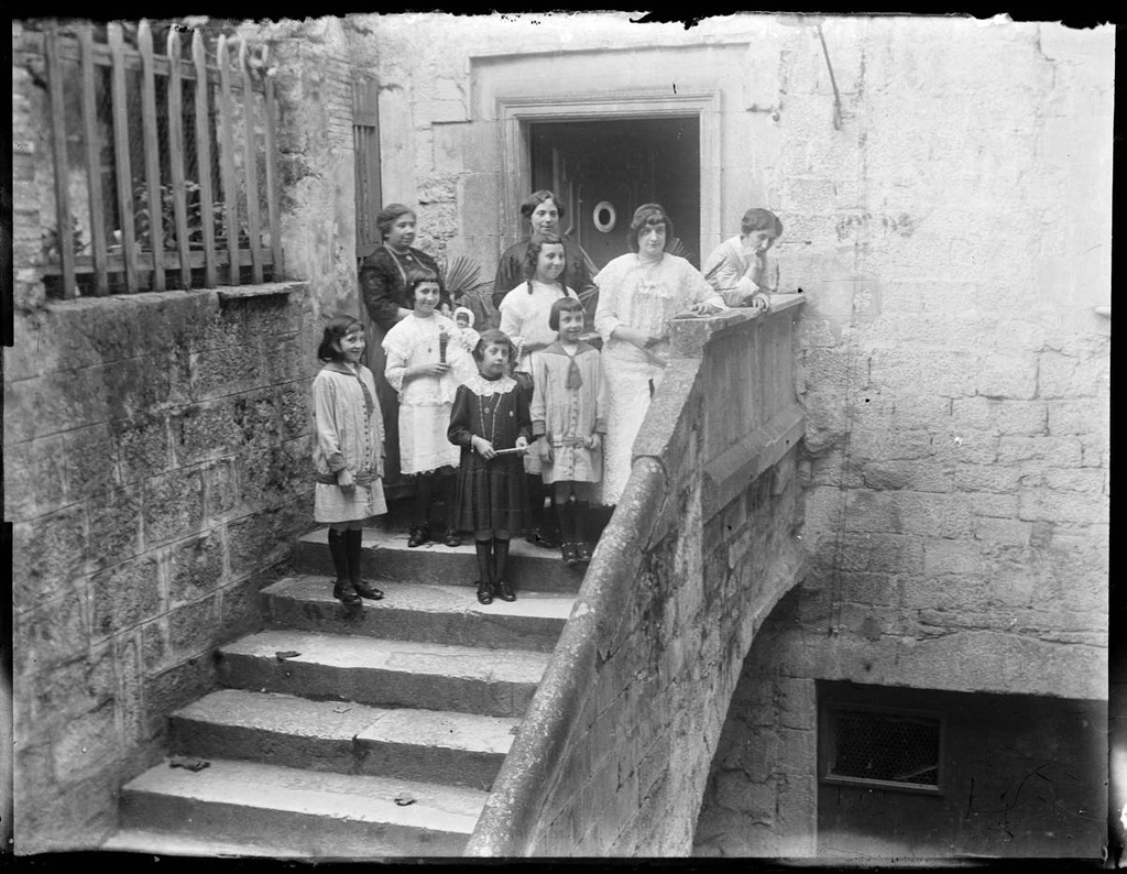 [Portrait at the scales of the Pabordia] - Members of the Boschmonar family, family and Bellsolà family on the stairs of Pabordia. The Boschmonar family lived in this building, in a rental apartment, from 1910 to 1922, when Daniel Boschmonar acquired the house no. 23 Street Force.