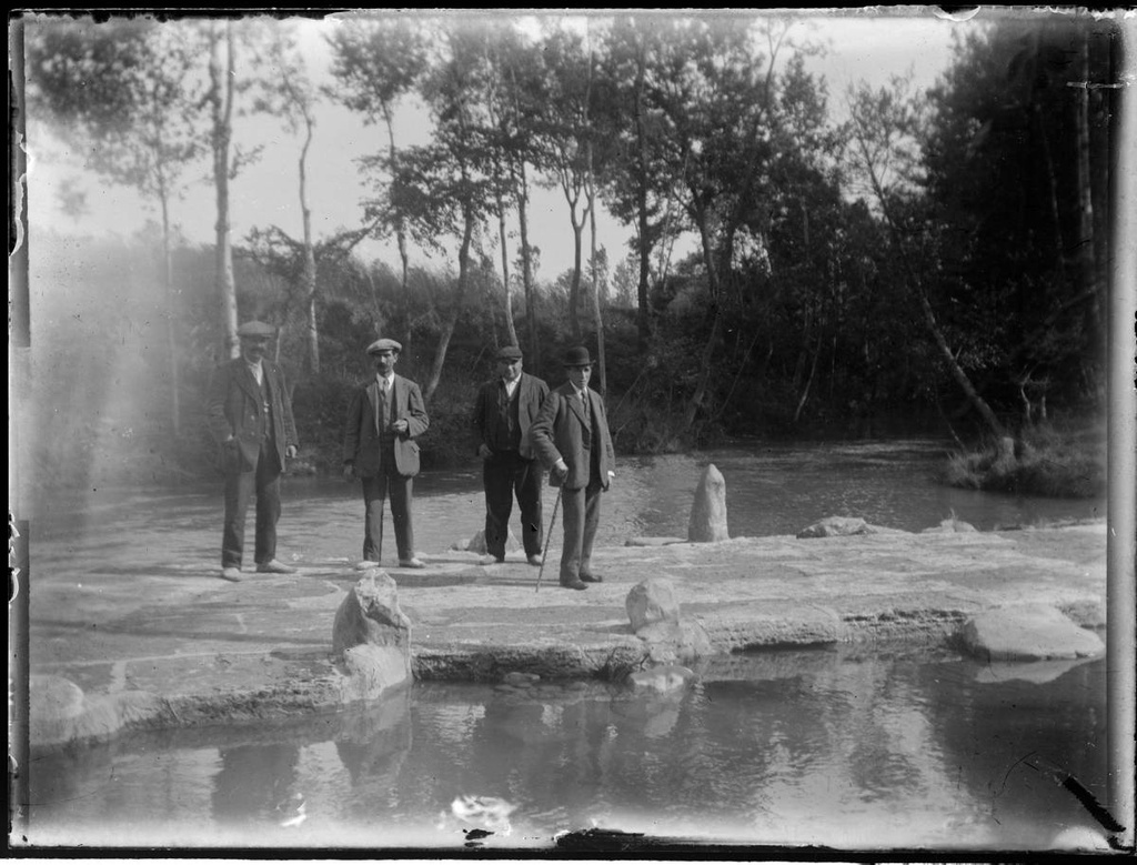 [Passage over a river] - Men on a sidewalk over a river.