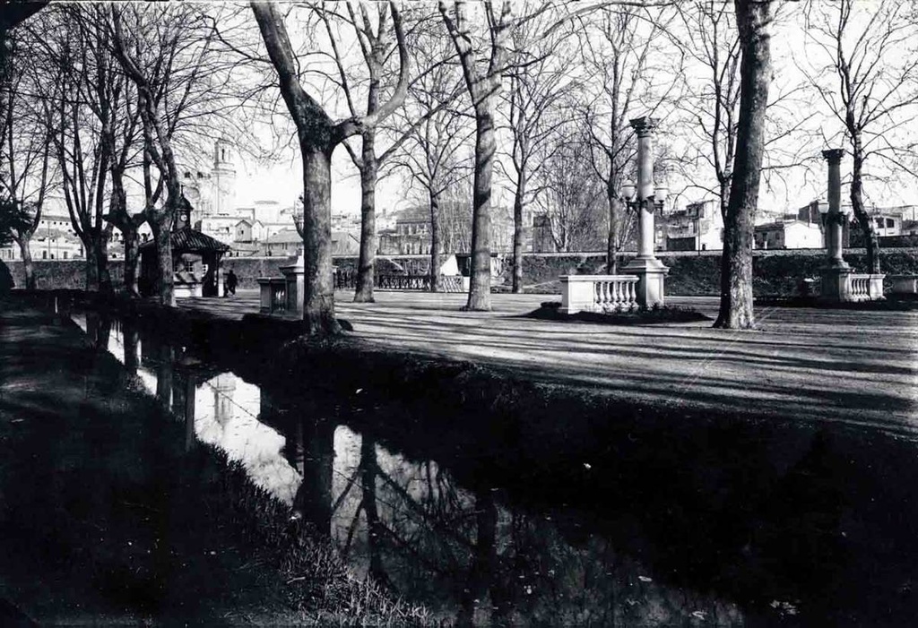[The Meadow] - The central promenade with the stream Devesa first. In the second term on the right, the balustrade and the columns from the boulevard Verdaguer In the background, the Clock House, the homonymous bridge and the train embankment.