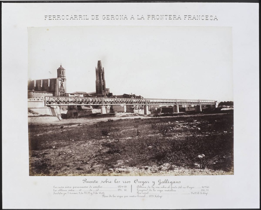 Railway from Gerona to the French Border. Bridge over the rivers Onyar and Galligants - Point of confluence between the rivers Ter and Onyar. In the central part, the railway bridge. In the background, the Cathedral of Girona and the bell church of Sant Feliu. On the right, the footbridge Portal de la Barca.