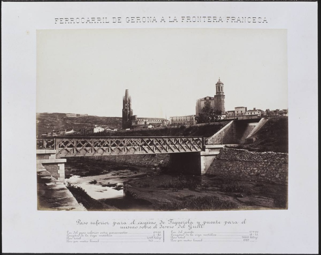 Railway from Gerona to the French Border. Lower pass for the Figuerola and flea road for the mismo on the Güell’s detour - The Clock Bridge over the river Güell. Secondly, the railroad embankment. In the background, from left to right, Montjuic mountain with the castle of the same name, the bell church of Sant Feliu and the Cathedral of Girona.