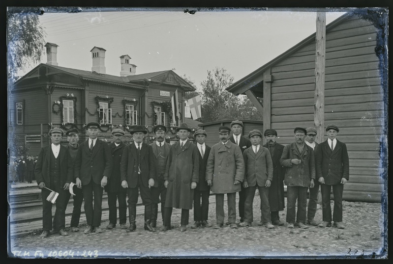 Grupipilt: 15 meest Raasiku raudteejaamas Soome presidendi külaskäigu puhul ehitud jaamahoone taustal