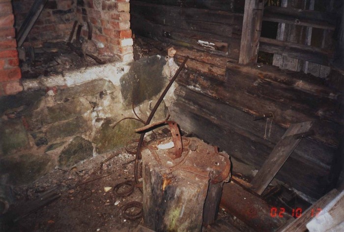 Mägipe küla saun-sepikoja sisevaade, esiplaanil alasipakk raudesemetega, taga vasakul ääs, paremal aken