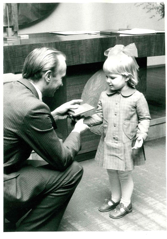Digitaalne kujutis. Tartu perekonnaseisuamet, Enn-Arno Sillari annab lapsele sünnimedali ja nimepäeva tunnistuse.  1985