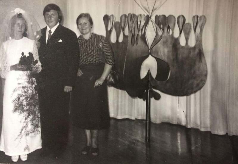 Digitaalne kujutis. Tartu perekonnaseisuamet, pulmapilt. Pruutpaar Viive ja Toomas Nummert ning kunstnik Siiri-Merike Nummert oma metalltaiese „Armuõis“ kõrval. 1975