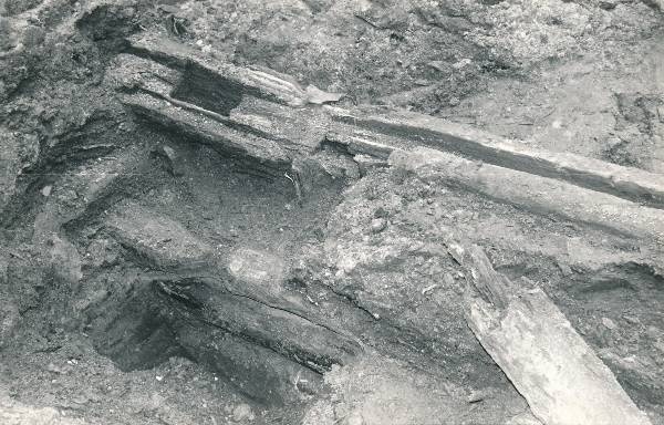 Arheoloogiline kaevamine Tartus 1979a. Puitrajatis linnamüüri ja 1775a hävinud kvartali vahelt mustast pinnasest.