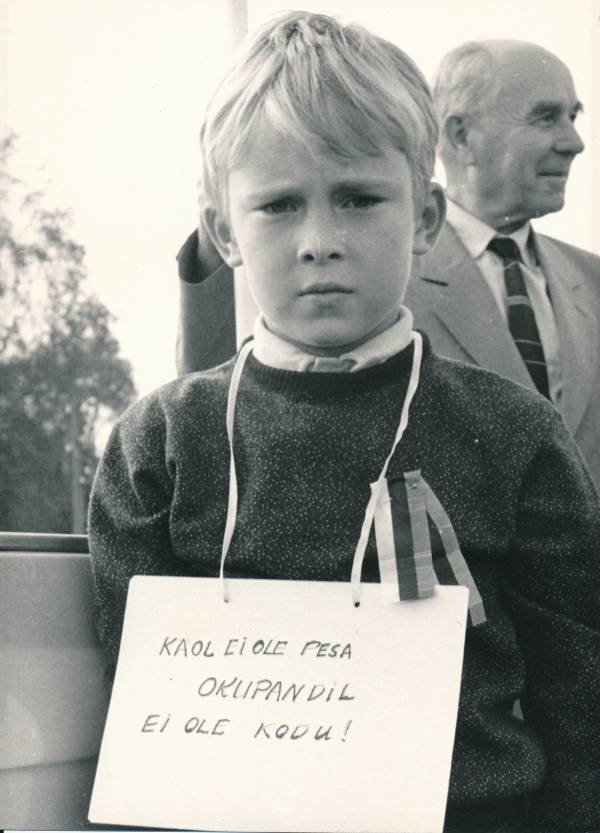 Miiting Tartus Raekoja platsil 1989a. Väike poiss, kel rinnas rahvusvärvidega lindike.