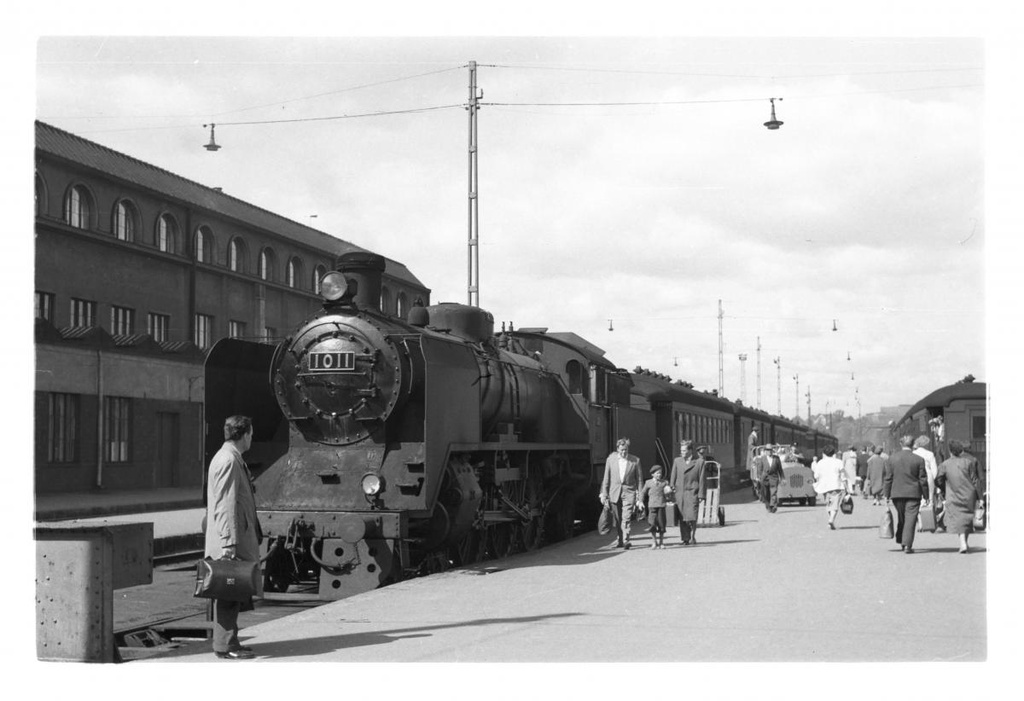 Höyryveturi Ukko-Pekka Hr1 sarjanumerolla 1011 ja matkustajia Helsingin rautatieasemalla.