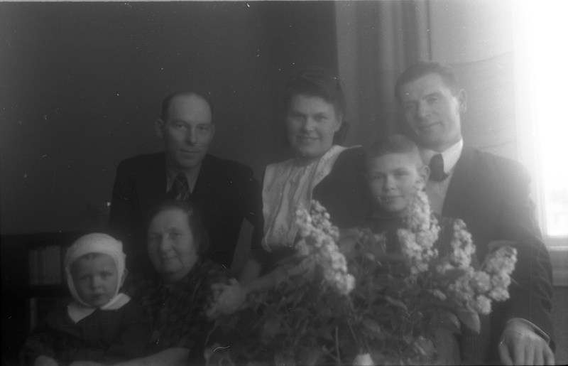 TRÜ psühhiaatriakateedri juhataja (1941–1975), arstiteaduskonna prodekaan ( 1944–1949)  Elmar Karu (paremalt esimene), abikaasa Leida Karu (paremalt kolmas), naine, mees ja kaks last lillede taga istumas