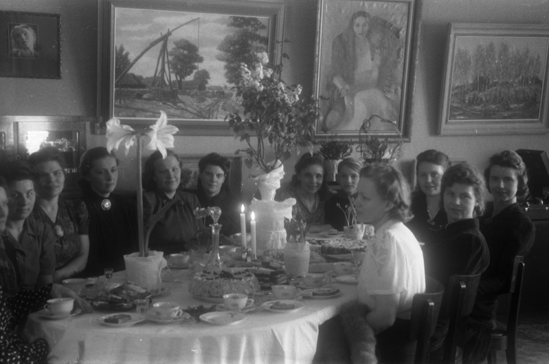 Tartu polikliiniku laboriarst Maria Jansen-Ora (vasakult seitsmes) koos tütre Liiviaga (vasakult kaheksas)? ning seltskonnaga ümber laua istumas (dr Ora oma perega)