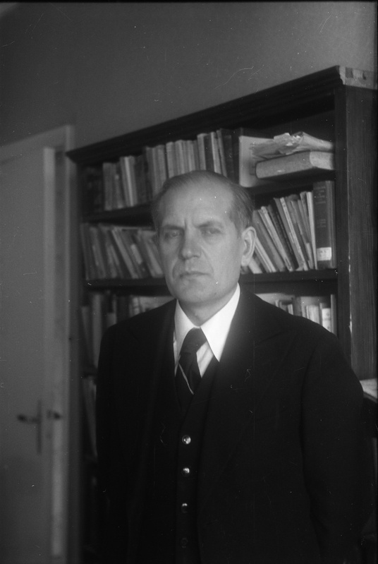 TRÜ rektor (1944–51) prof Alfred Koort oma kodus raamaturiiuli taustal seismas