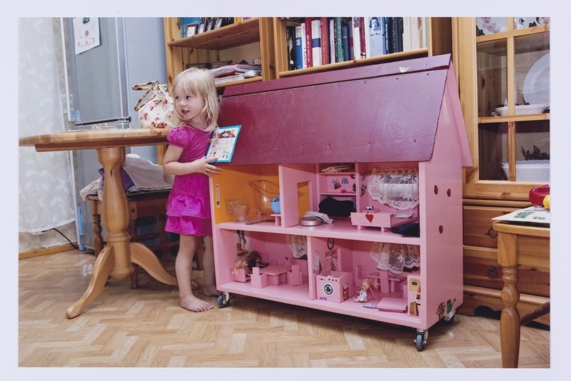 Väike tüdruk nukumajaga