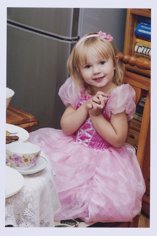 Väike tüdruk printsessikleidis oma 3. sünnipäeval