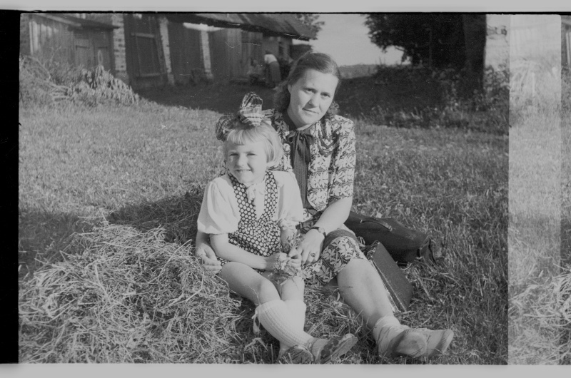 Ema lapsega murul istumas