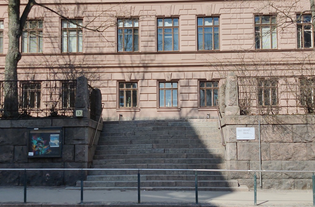 Liisankatu 13. Koulun huurteiset, lumiset portaat penkkariajelupäivänä Liisankatu 13:ssa. Portaiden yläpäässä banderolli, jossa teksti ARBEIT MACHT FREI?!. rephoto