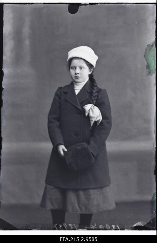 Patsiga tüdruk talveriietes ja muhviga.