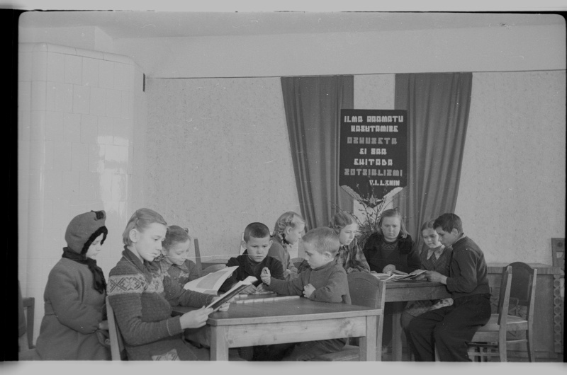 Õpilased laua ümber raamatuid lugemas