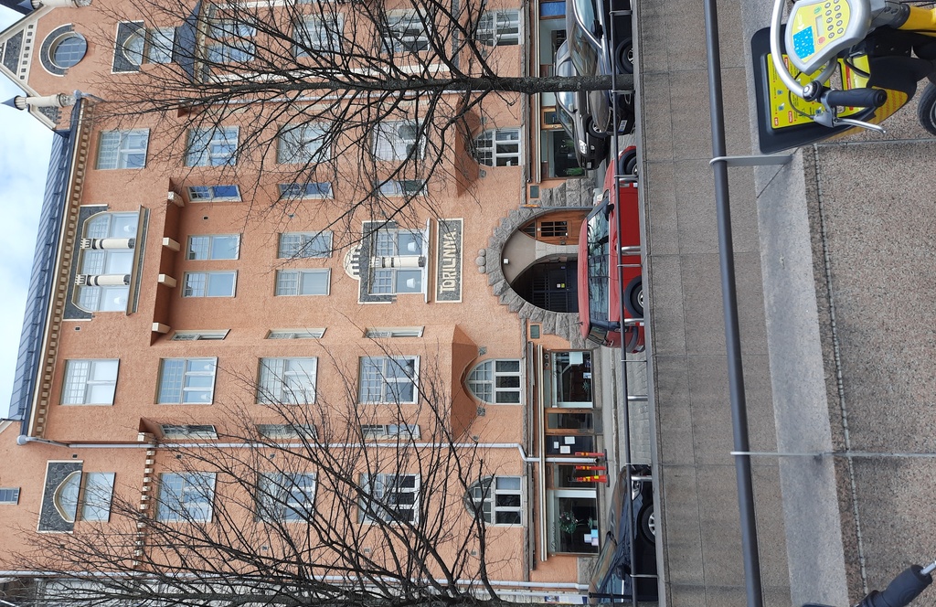 Fabianinkatu 13. Ihmisiä kävelemässä sateisella Fabianinkadulla jugendtalo Torilinnan sisäänkäynnin ja porttikäytävän edustalla Kasarmitorin laidalla. rephoto
