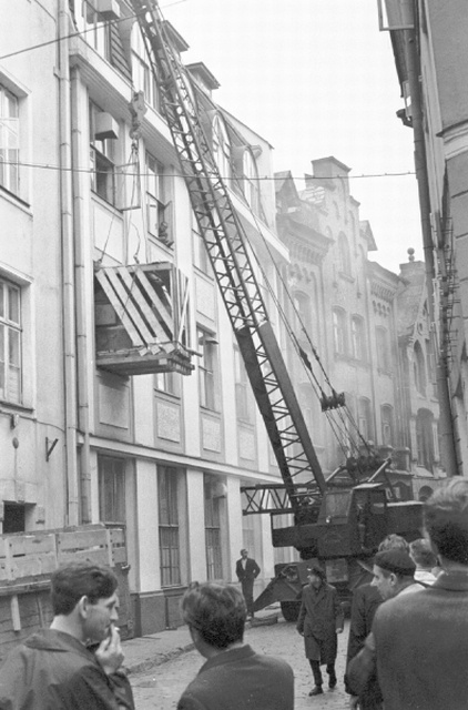 Kraana Tallinna vanalinnas maja aknast suurt kasti sisse tõstmas.