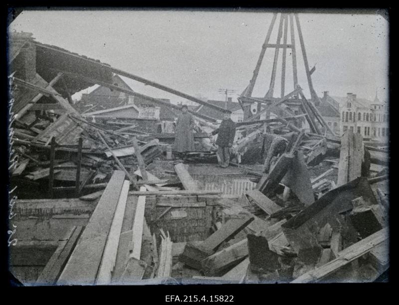 Kaks inimest Saksa tsepeliinilt pommitabamuse saanud hoone (Eduard Koppeli maja Lossi ja Munga tänava nurgal) ülemise korruse purustuste keskel, (foto tellija majaelanik hambaarst Karl Reinhold).