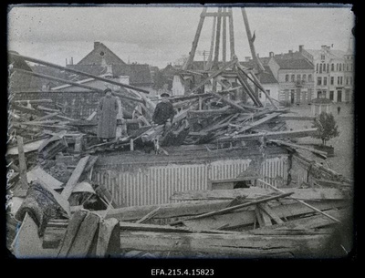 Kaks inimest Saksa tsepeliinilt pommitabamuse saanud hoone (Eduard Koppeli maja Lossi ja Munga tänava nurgal) ülemise korruse purustuste keskel, (foto tellija majaelanik hambaarst Karl Reinhold).  similar photo