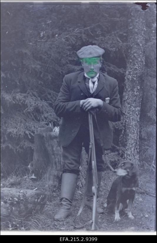 Nöörmann jahipüssi ja koeraga looduses.