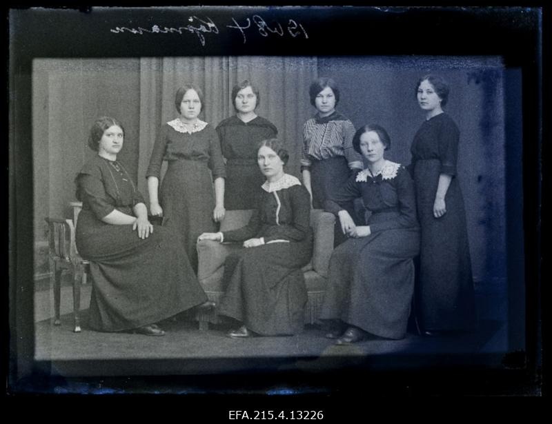 Grupp naisi, keskel istub foto tellija Kõpmann.