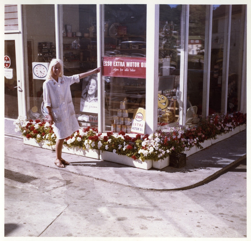 Tvedestrand, Sannidal gas station. Følgebrev: "Vedlag oversendes en del billeder for Esso Service. The blonde pien har i summer vært ansatt hos Tengel Hagestad i Tvedestrand. Hun heter Kari Rømyr og er søster til bestyreren på stasjonen. Begge disse, både Johan og Kari har encompass the stasjonen, og det kvinnelige innslag er vel inne i alle forhold på petrolstasjonen. At Kundene setter pris på det blomstrende innslag cheese seg selv. Lead Sannidal Bensinstasjon har det vært et rikt blomsterflor i light sommer til stor glede for trafikkantene på riksveg 40. Forhandler er Gunn Johanne Rønning." Sign Jone Vadla.