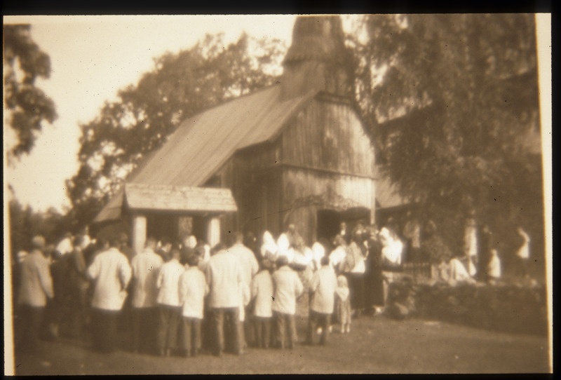 Slaidid Ruhnust ja ruhnlastest nr. 2 külarahvas kogunenud puukiriku ette (foto peegelpildis)