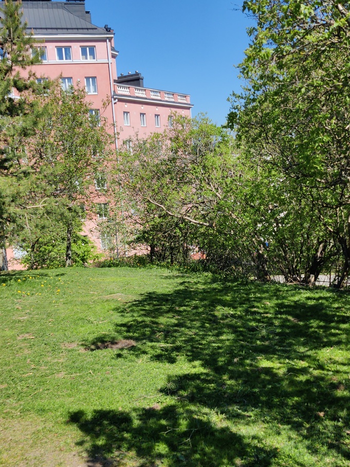 Kolme tyttöä istumassa kallioilla Katri Valan puistossa, takana Vilhonvuorenkuja 20. rephoto