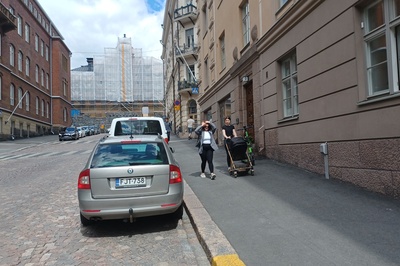 Kruununhaka, Snellmaninkatu. Jonossa kulkevia lapsia sekä lastenvaunuja työntävä nainen kävelemässä ylös lumikinoksen kaventamaa Snellmaninkatua Liisankadun kulmasta Oikokadulle päin. Oikealla Elannon myymälä ja taaempana lihakaupan kyltti. rephoto