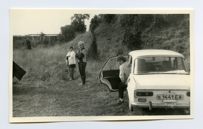 Allveearheoloogia klubi "Viikar" telklaager Maasilinna ordulinnuse vallikraavis. Telkide vahel Vaike Raudsepp, Katrin Sepalaan. Autost astub välja Taimi Mäss. 
1987